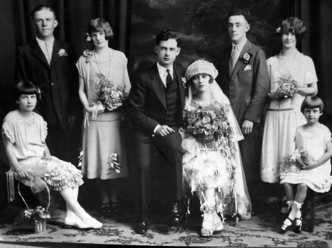 The wedding party of groom Carl Henry Frank Hanneman, 23, and Ruby Viola Treutel, 21. Wedding was July 14, 1925 at St. James Catholic Church, Vesper, Wis. At front left is flower girl Nina Treutel, 11, sister of the bride. At front right is ring-bearer Elaine Treutel, 5, sister of the bride. Across the back, left to right, are Joe Ladick (bride's cousin), Gladys Cole (bride's cousin), groom Carl Hanneman, bride Ruby V. Hanneman, best man Wendell Miscoll, and maid of honor Esther Allbrecht.