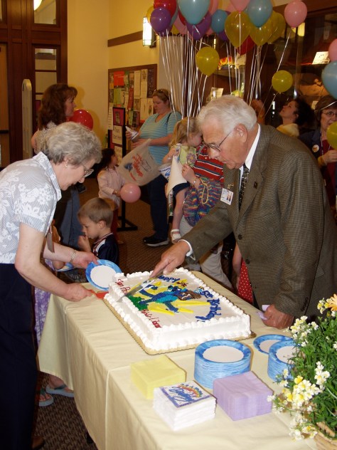 Mayor Dave Hanneman cuts the cake at the 5th birthday of the new Sun Prairie Public Library.