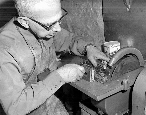 Wilbert G. Hanneman uses a diamond saw to cut slabs of Australian imperial red rhodomite.
