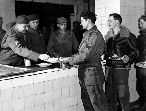 Staff Sgt. Charles D. Grinolds of Mauston (second in line) waits to be administered a sulfa pill, part of a U.S. Army Air Force effort to reduce illness at the 91st Bomb Group in England during World War II.